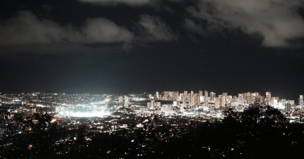 タンタラスの丘から見るワイキキの夜景。都市の明かりが星のように輝き、海は夜の闇に包まれています。